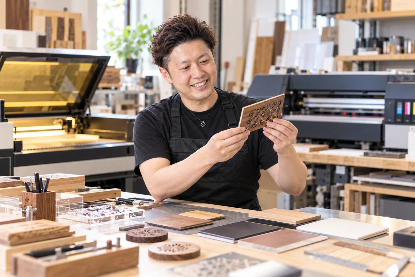 本人写真を参照して生成した、工房で木材とアクリルの試作品を確認する制作イメージ