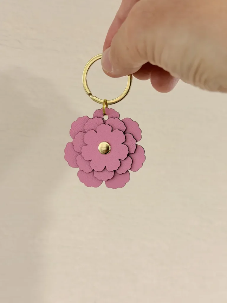 手に持ったピンク系の花型チャーム