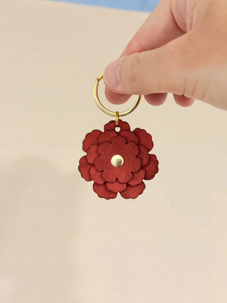 手に持った赤系の花型チャーム